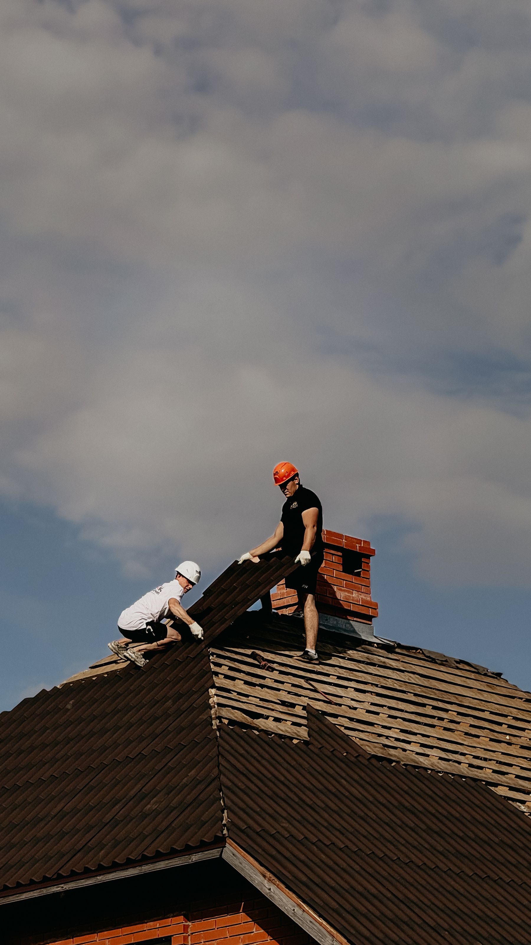 Zwei Dachdecker reparieren ein Dach